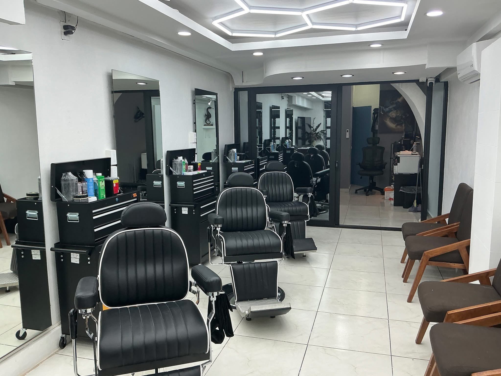 Interior of The View Barber Shop: a row of leather barber chairs facing mirrored stations beneath a hexagonal ceiling light.